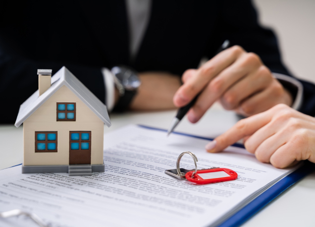 homme en costume qui tient un stylo pour la signature d'un contrat immobilier dans les yvelines 78